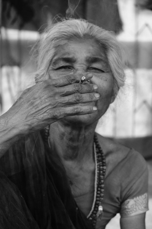 Free Evocative black and white portrait capturing an elderly Indian woman smoking in Patna, India. Stock Photo