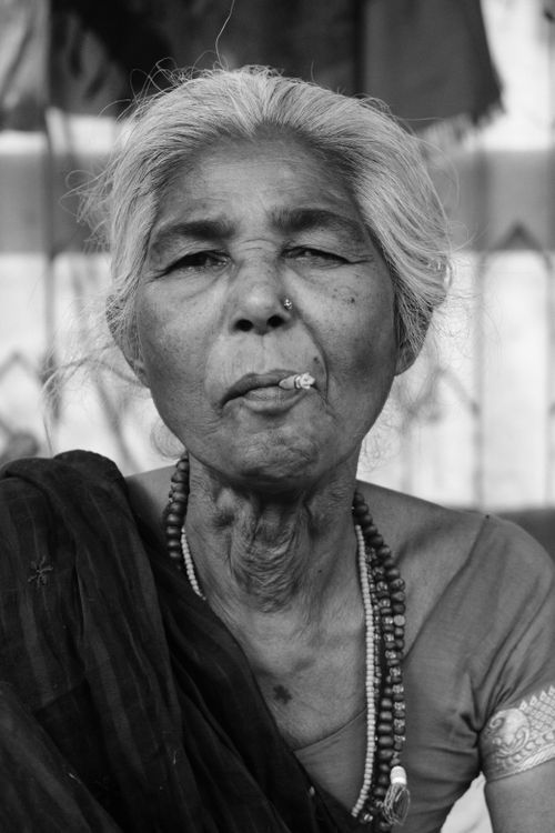 Free Black and white portrait of an elderly Indian woman smoking in Patna market. Stock Photo