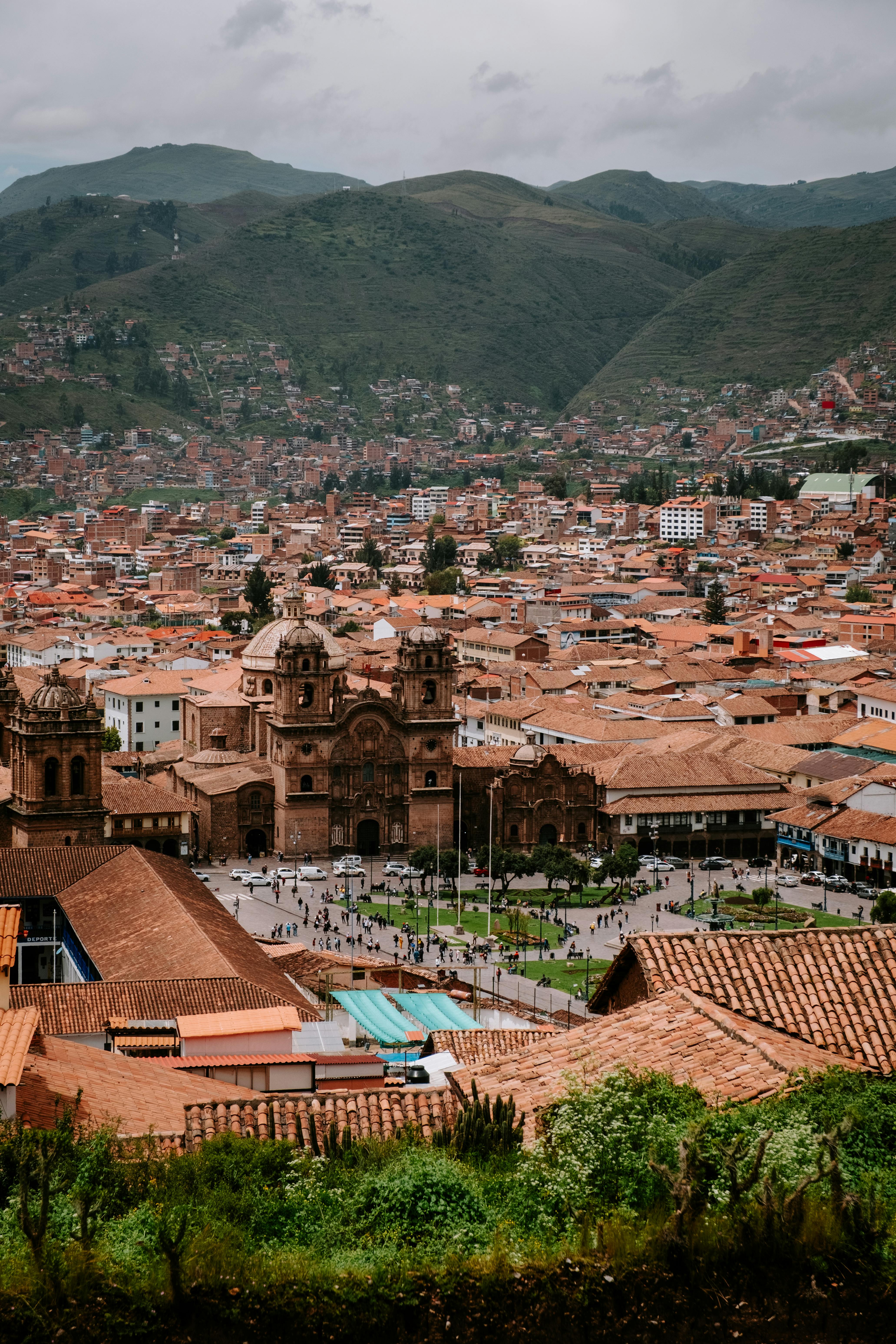 Aerial view of Cusco's historic cathedral in the town square surrounded by Andes mountains.