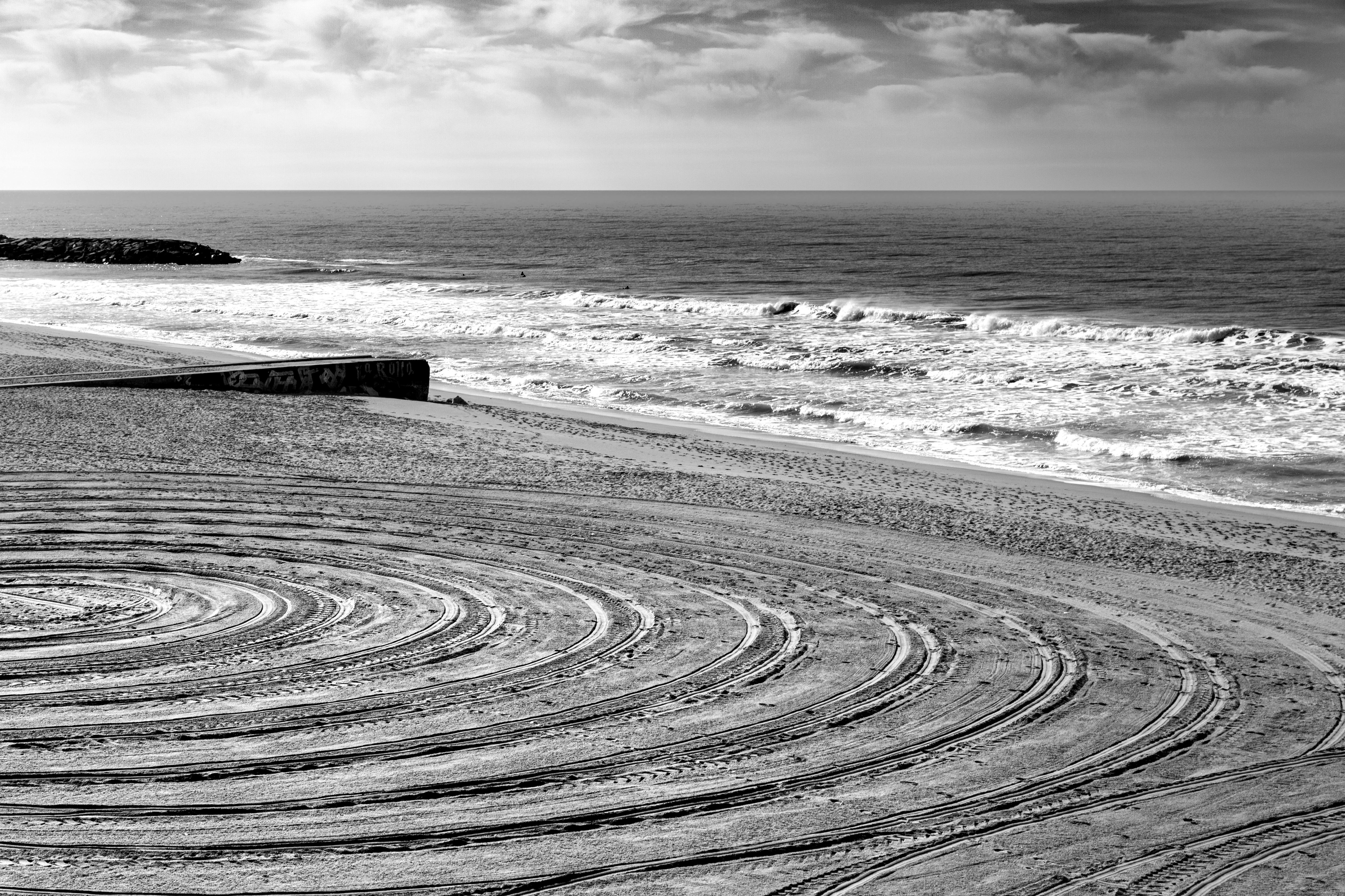 Serene black and white beach scene with concentric circles in the sand at Mar del Plata, Argentina.