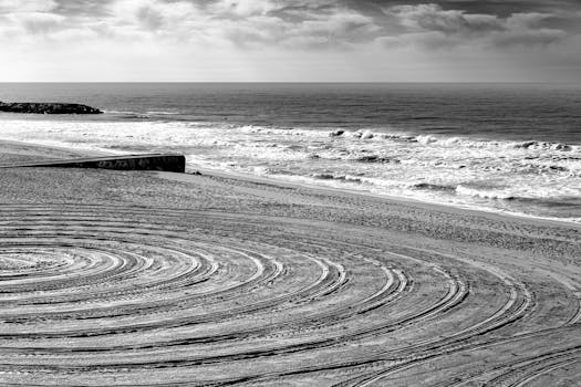 Serene black and white beach scene with concentric circles in the sand at Mar del Plata, Argentina.