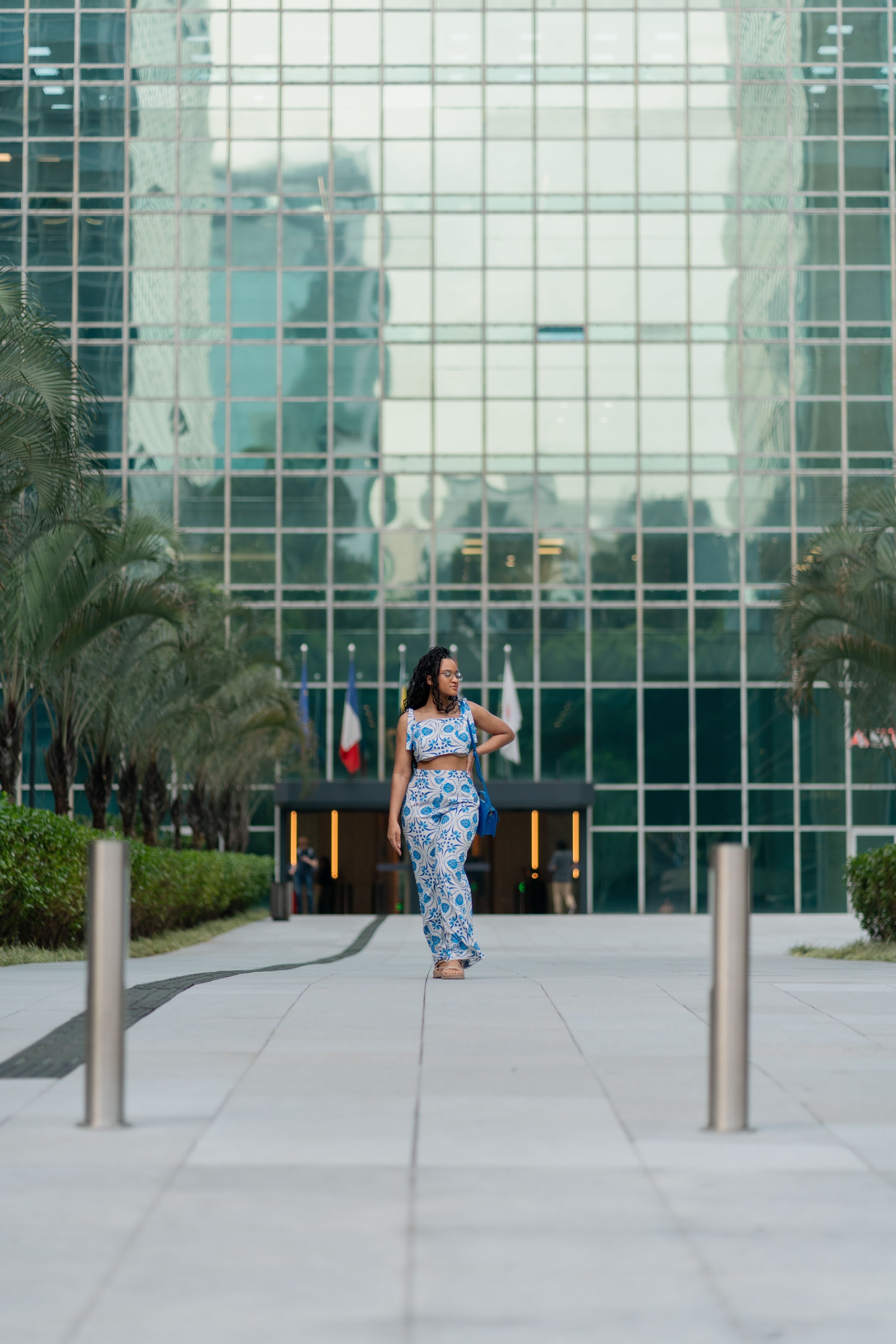 Woman in Floral Dress Walking by Modern Building · Free Stock Photo