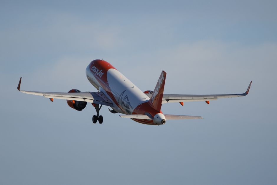 Airplane in flight against a clear blue sky, showcasing modern aviation.