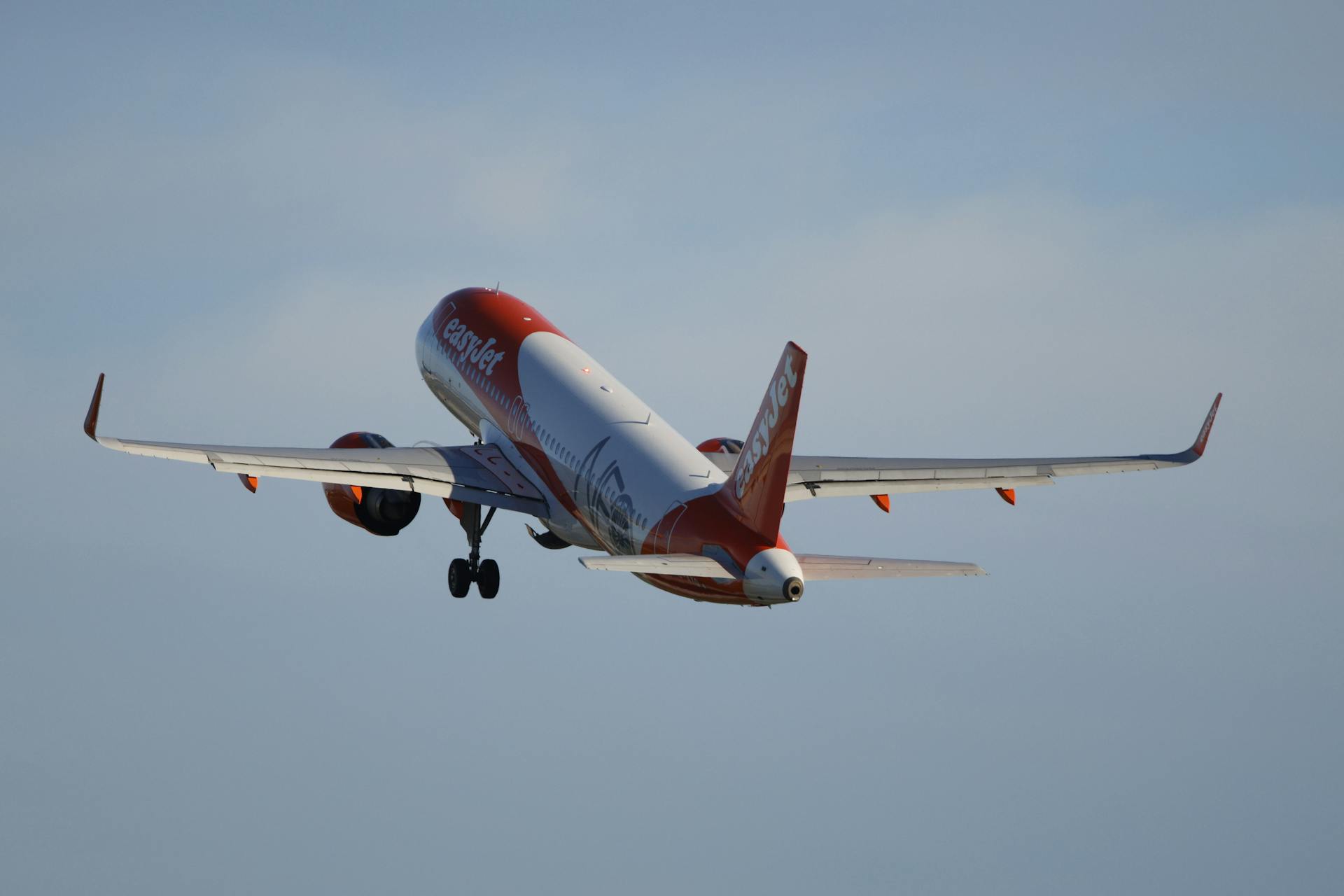 Airplane in flight against a clear blue sky, showcasing modern aviation.