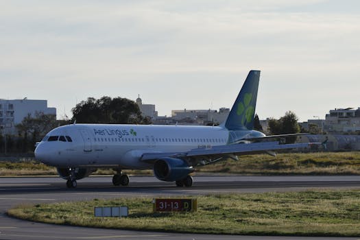Aer Lingus Airbus A320 taxiing on runway under clear sky.