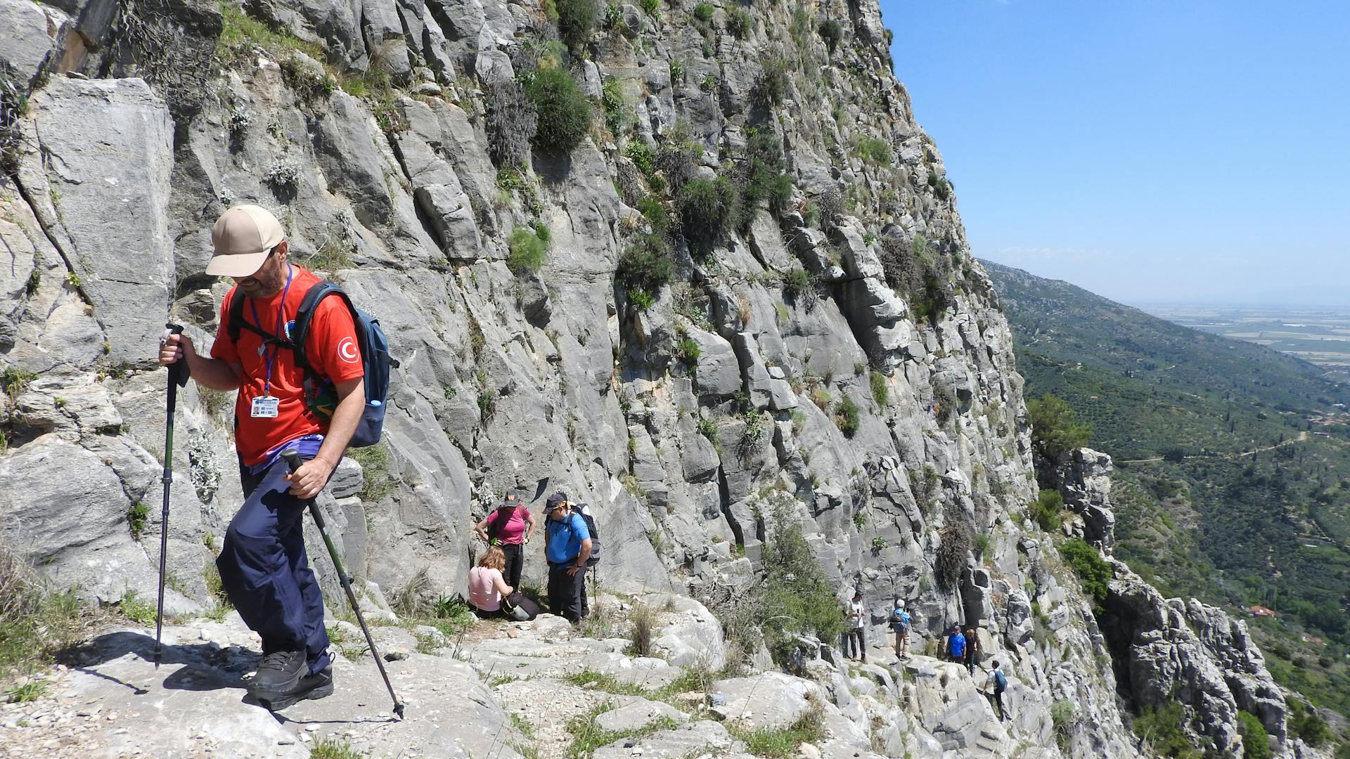 A group of hikers traversing a rugged mountain path during daytime, showcasing adventure.