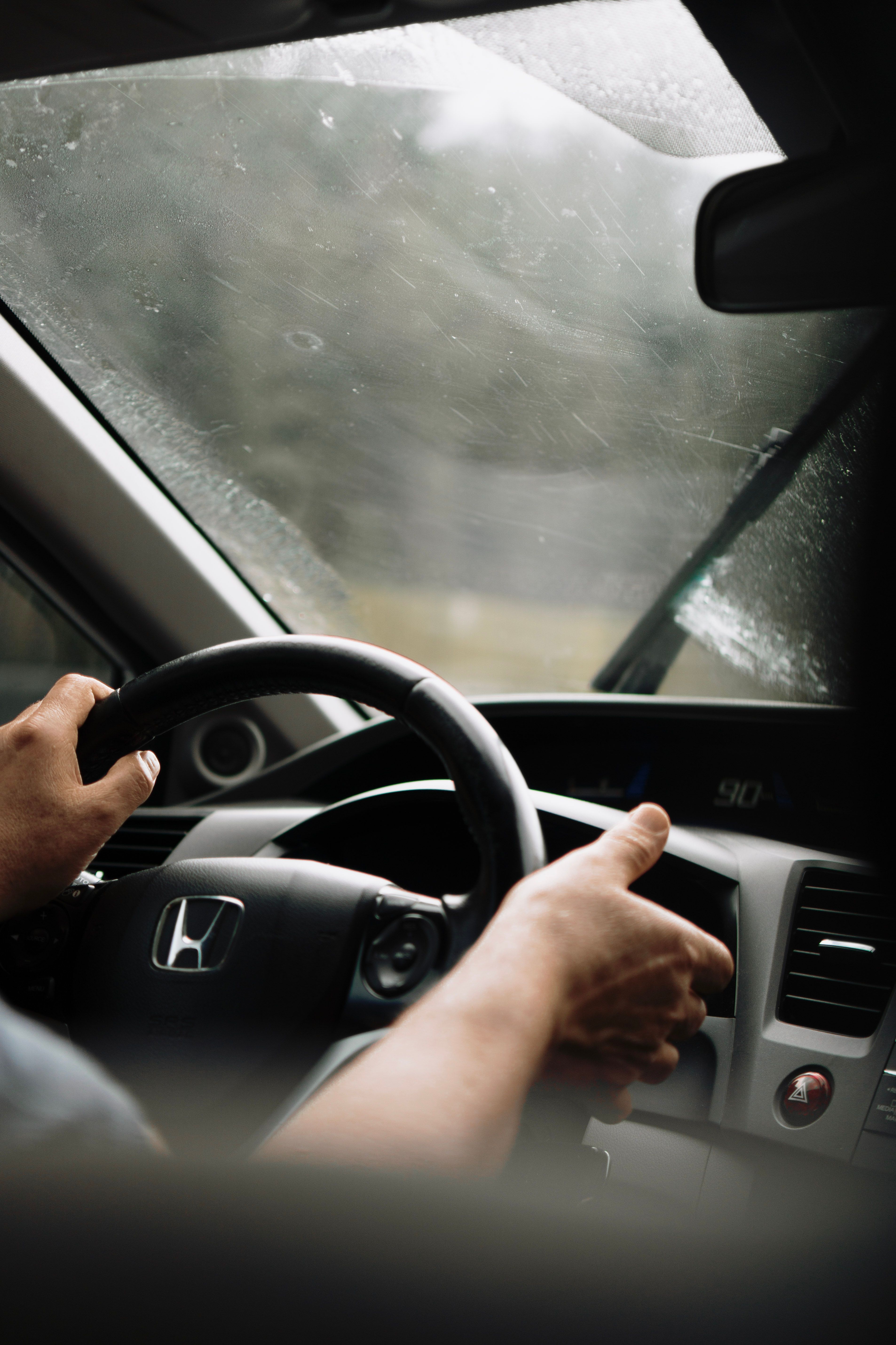 Man Driving a Car on a Rainy Day · Free Stock Photo