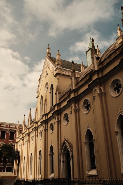 Free Exterior view of ornate Gothic-style church facade with detailed architectural features against a blue sky. Stock Photo