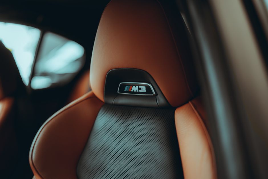 優れた級のレザーとデザインを披露する、M3 ロゴが入った高級車のシートのクローズアップ。