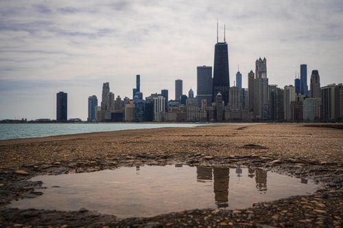 Free Beautiful view of the Chicago skyline with skyscraper reflections on wet ground under cloudy skies. Stock Photo