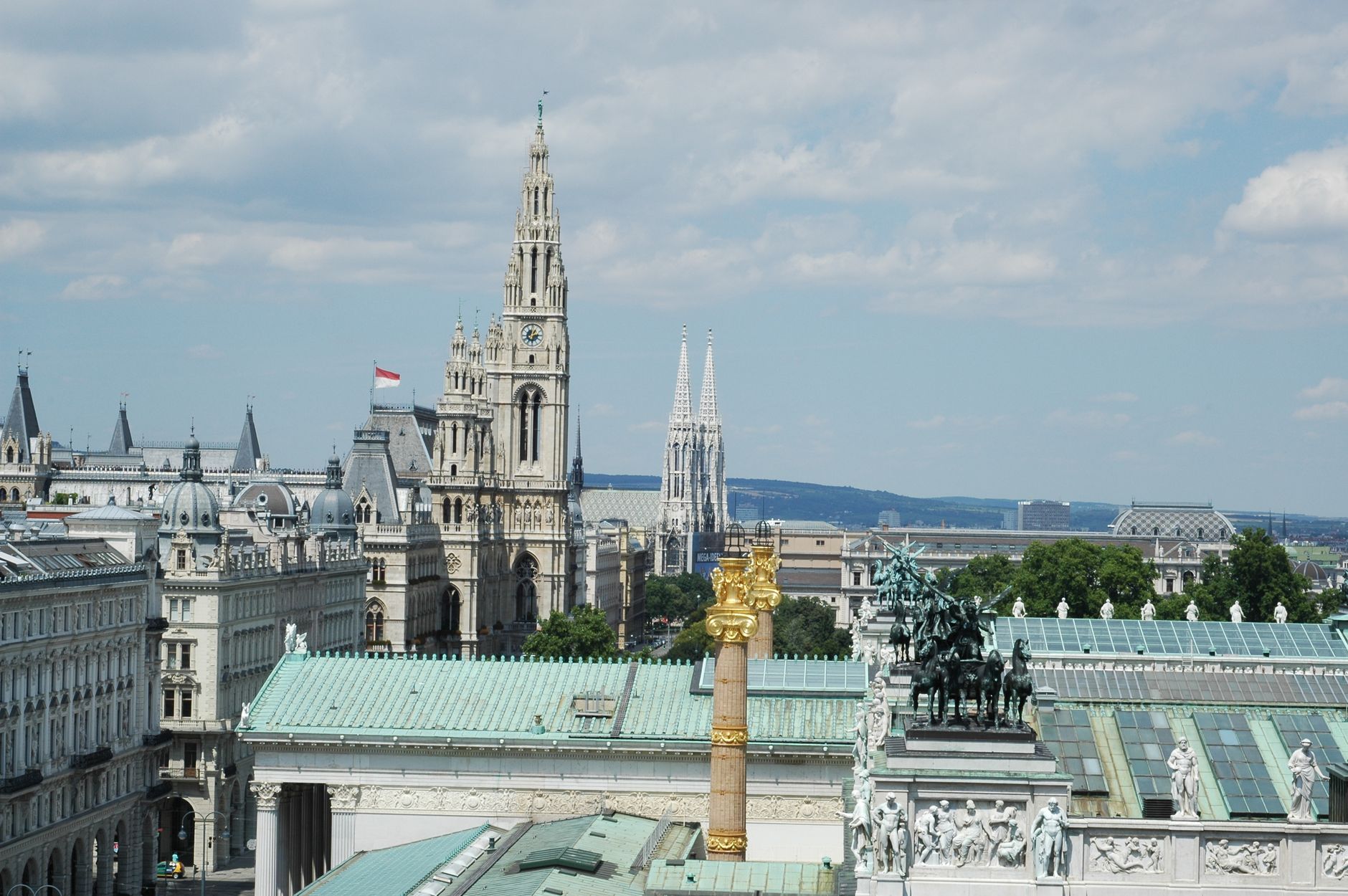 Aerial view of Vienna showcasing the town hall, Votivkirche, and architectural landmarks.