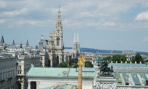 Aerial view of Vienna showcasing the town hall, Votivkirche, and architectural landmarks.