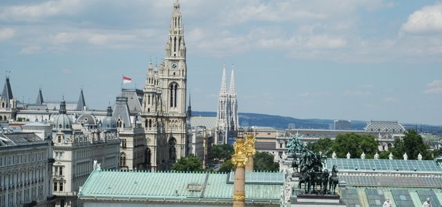 Aerial view of Vienna showcasing the town hall, Votivkirche, and architectural landmarks.