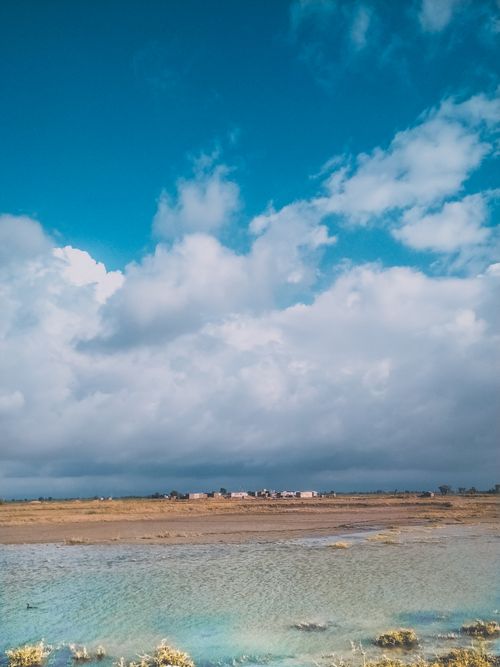 Free Expansive view of a rural landscape in Pakistan under a dramatic cloudy sky, showcasing natural beauty. Stock Photo