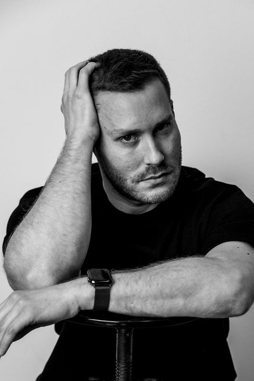 Free Black and white portrait of a man sitting pensively with a hand on his head. Stock Photo
