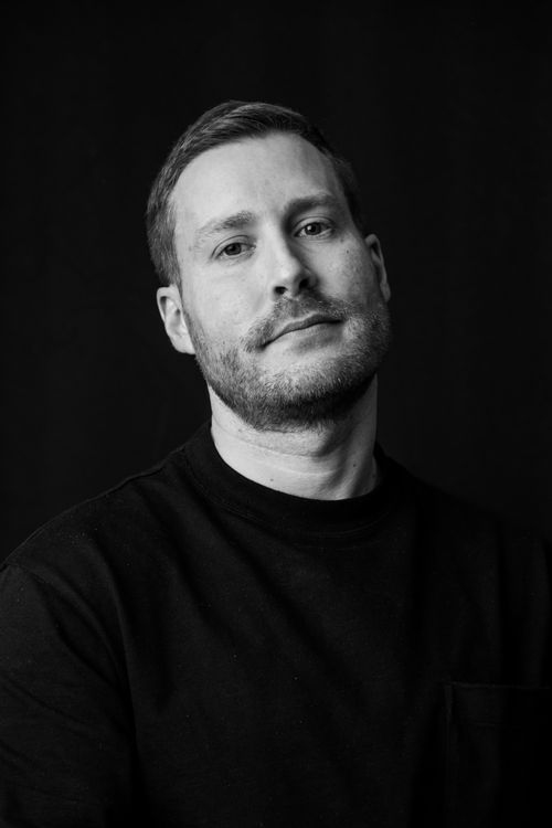 Free A contemplative man poses in a black and white artistic portrait. Stock Photo