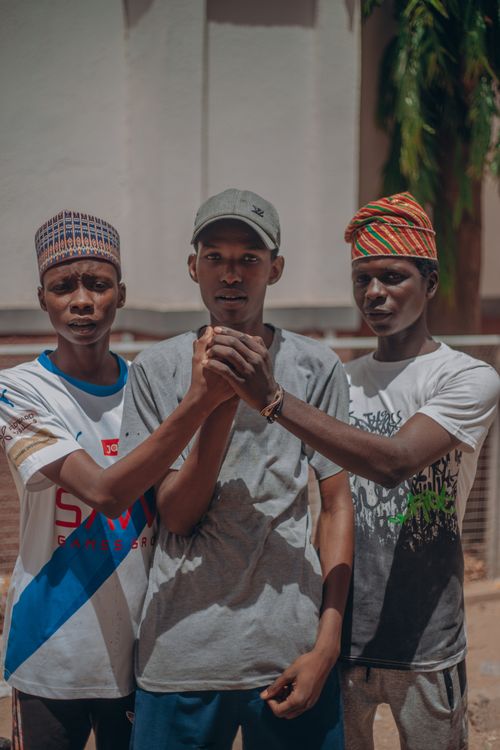 Free Three young men stand united outdoors, displaying camaraderie and friendship. Stock Photo