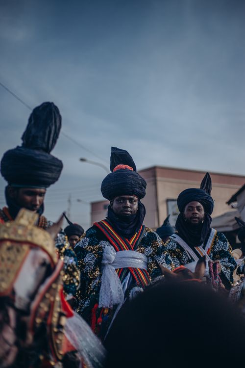 Free African horsemen in elaborate cultural attire participate in a traditional ceremony. Stock Photo