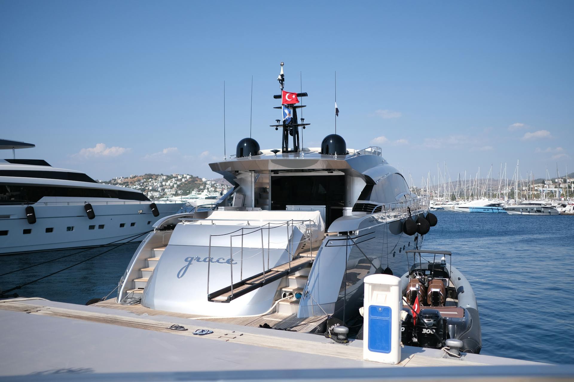 Elegant yacht at marina on sunny day, displaying Turkish flag, ideal for travel and lifestyle themes.