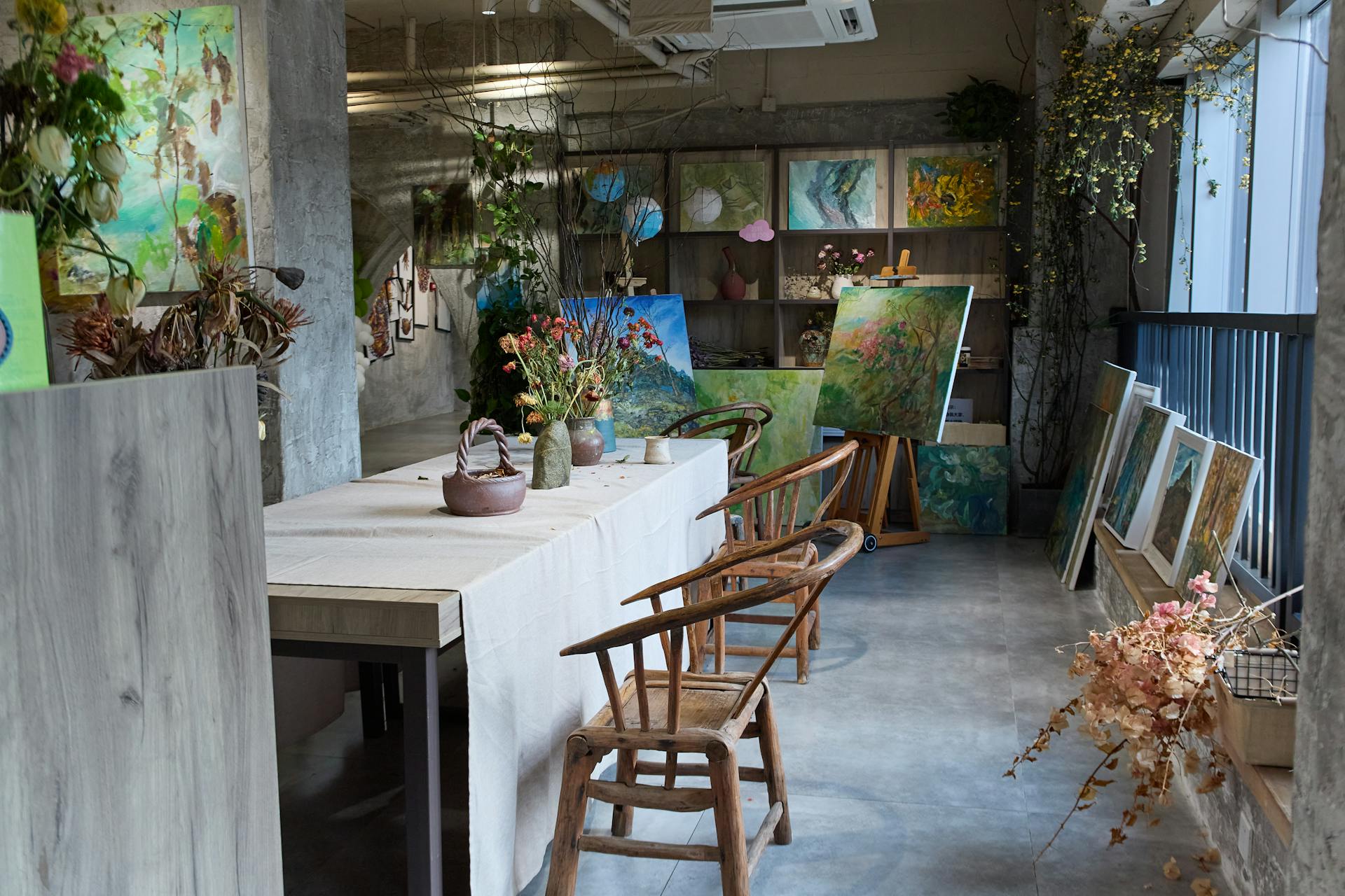 Bright and inviting art studio filled with colorful paintings and floral arrangements.