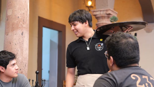 Waiter interacting with customers in a charming Mexican restaurant in Guanajuato.