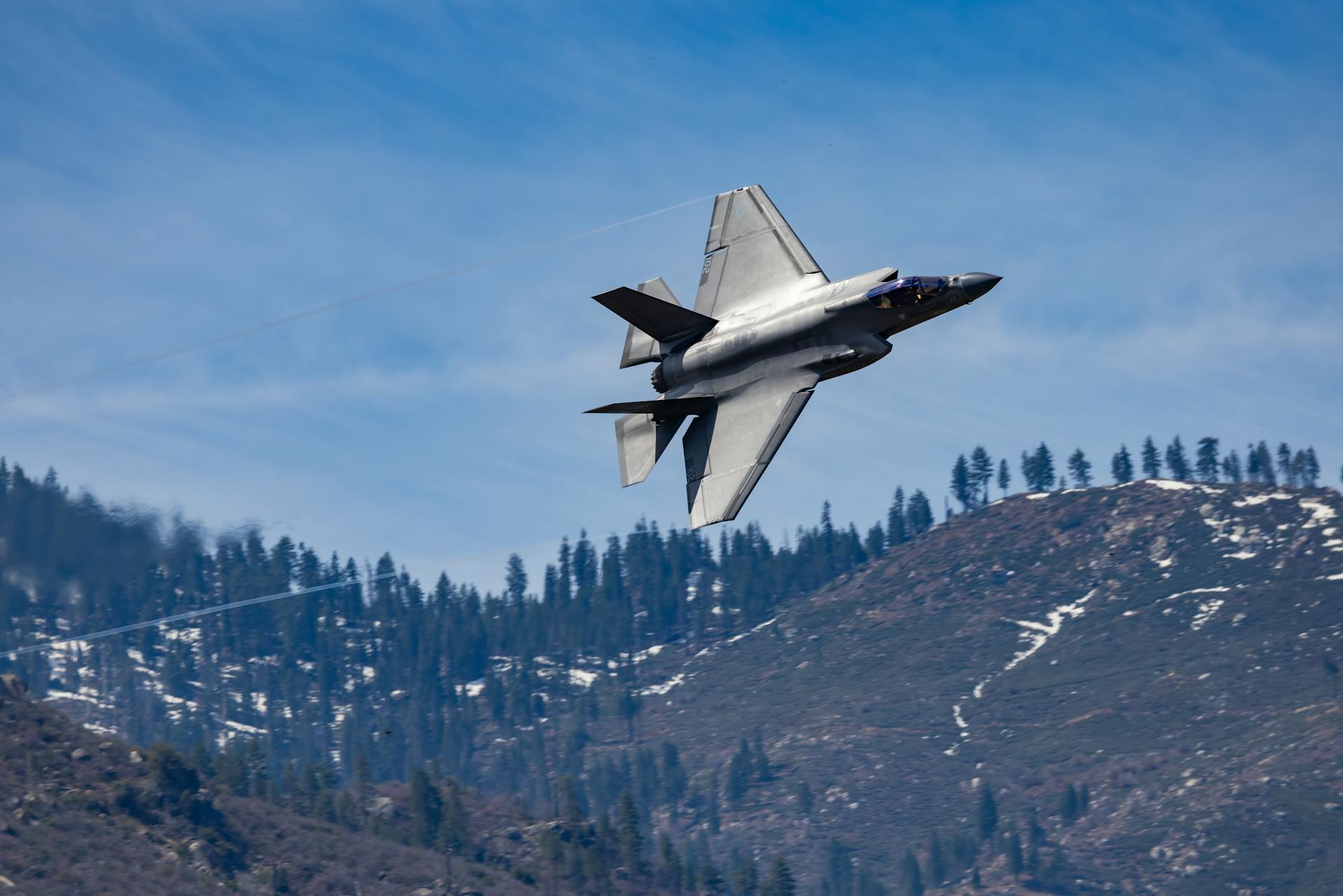 F-35 Lightning II jet captured in flight over scenic Kernville mountains, California.