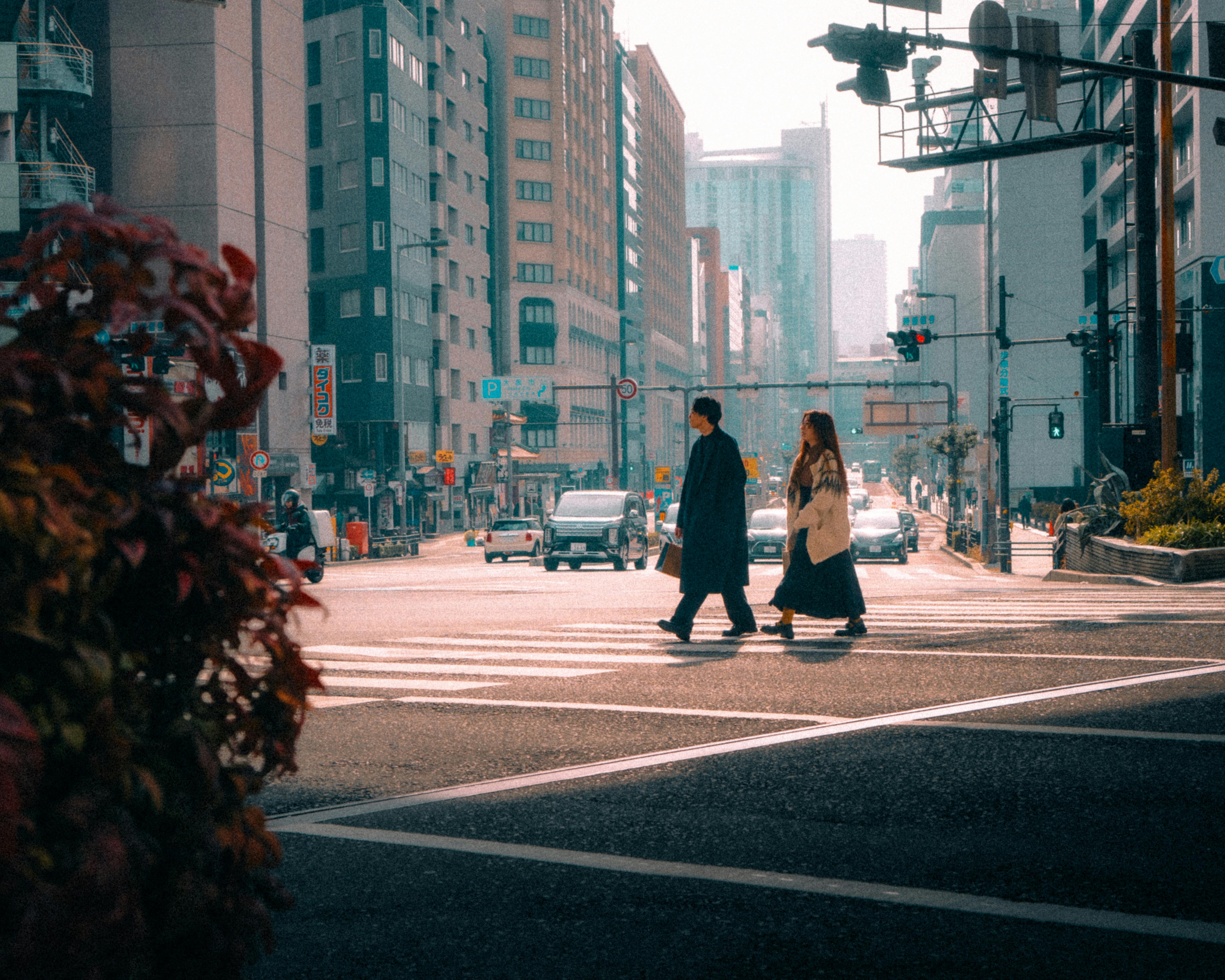 無料 日本の大阪の都市の街並み。交通量の多い交差点を歩行者が横断している。 写真素材