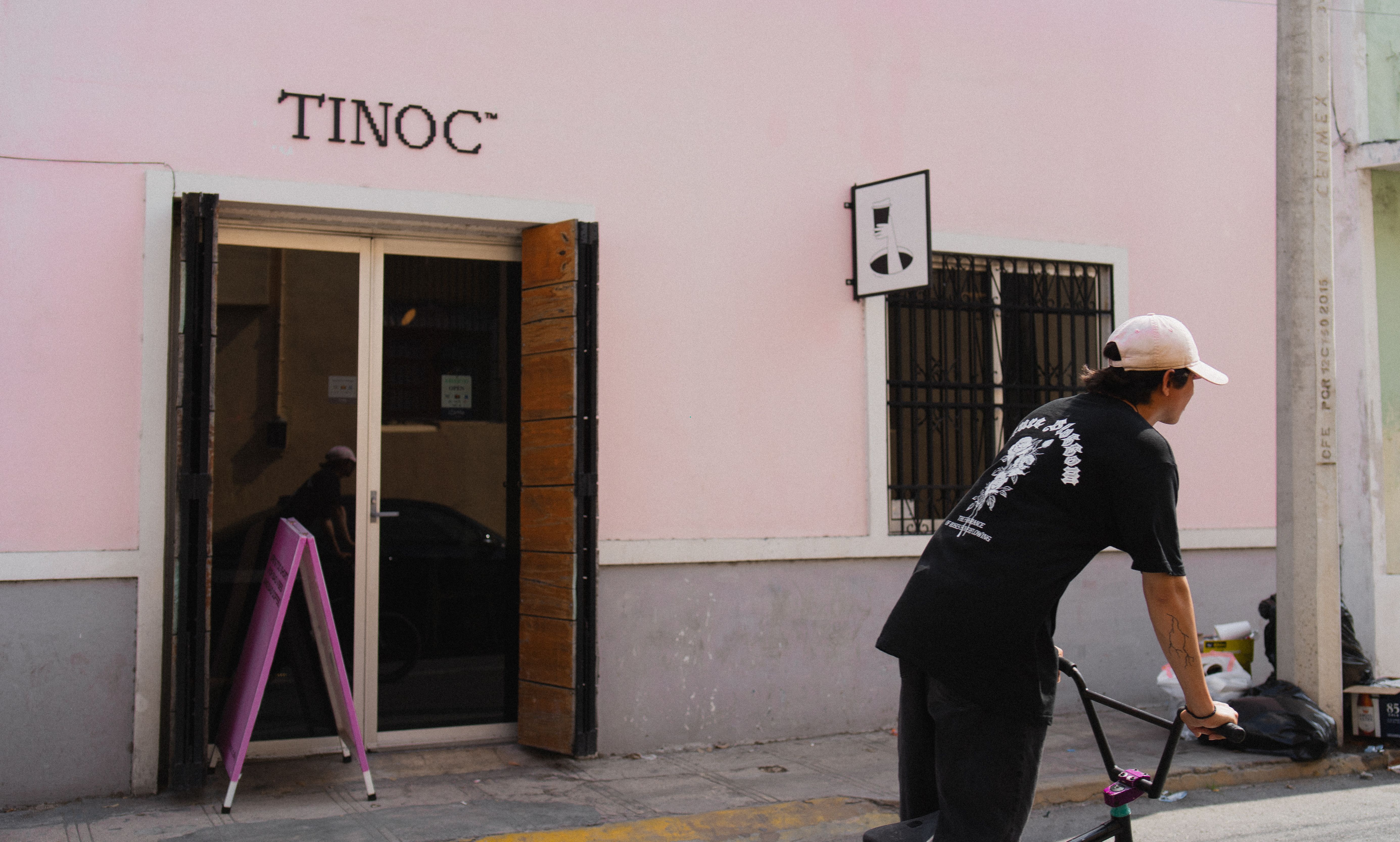 A street scene of a man on a bike near Tinoc Cafe in Merida, Mexico.