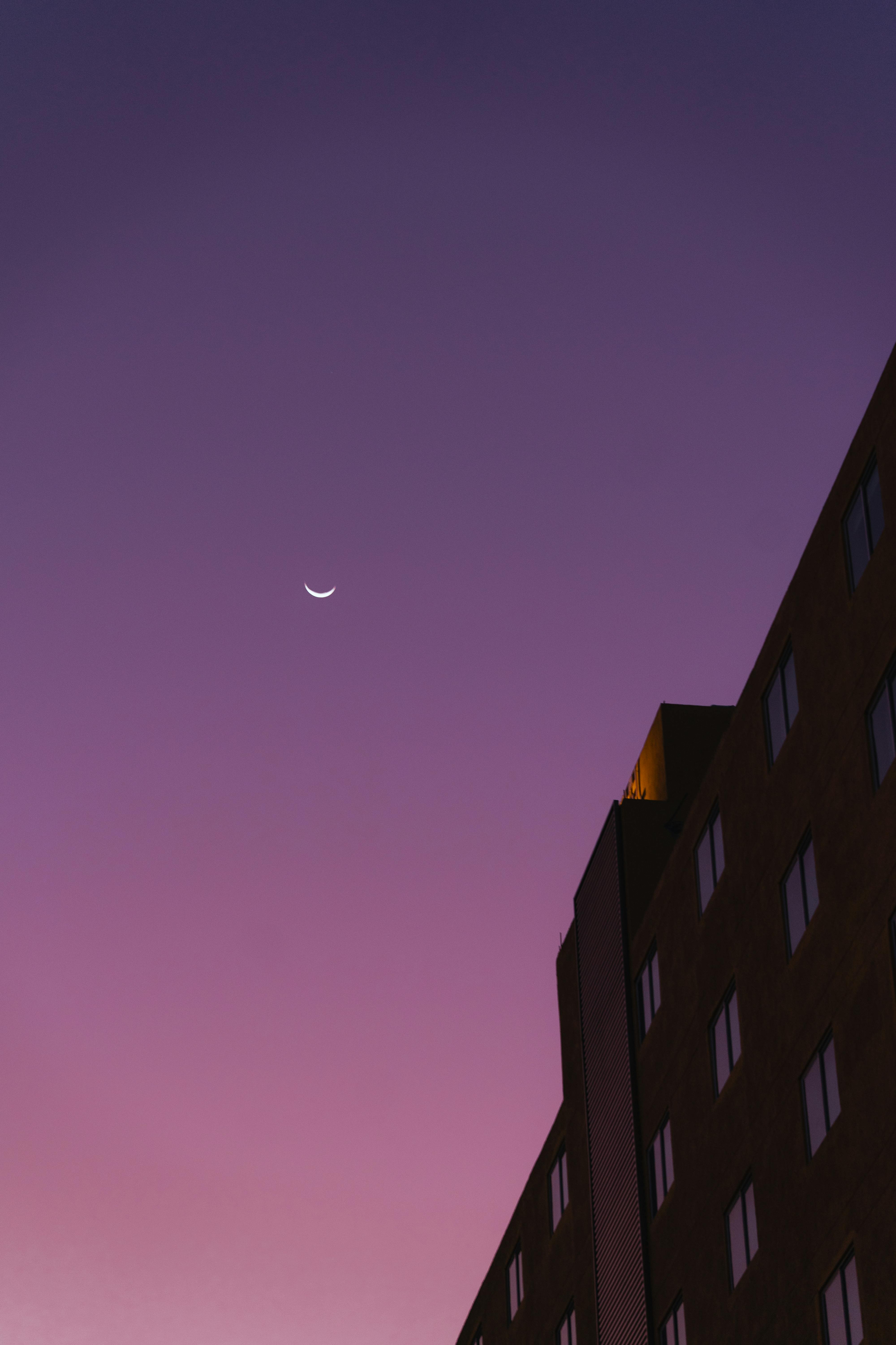 A serene twilight sky with a crescent moon above a building in Merida, Yucatan.