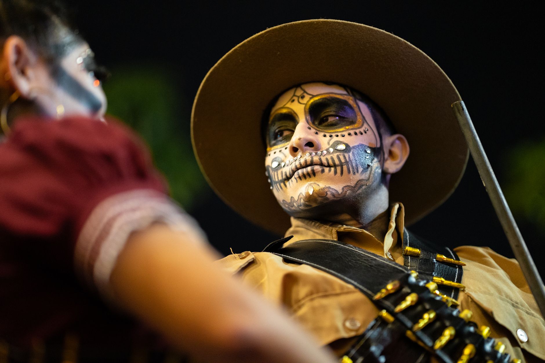 Vibrant Day of the Dead makeup and costumes in Merida, Yucatan, Mexico during a cultural parade.