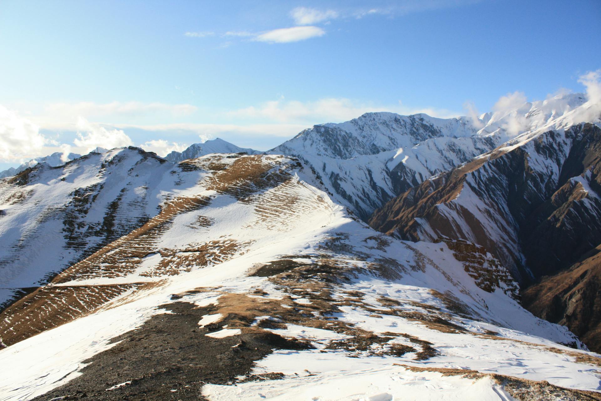 Stunning view of a snow-covered mountain range under a bright blue sky, perfect for winter adventures.