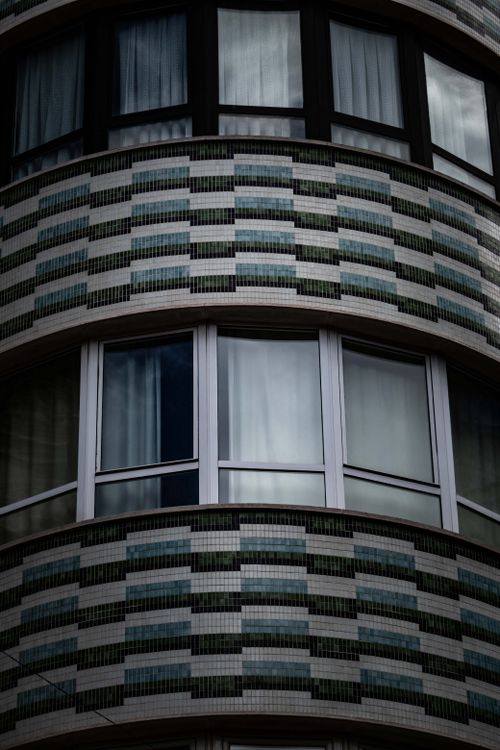 Free Close-up of a round modern building facade with unique tile pattern and multiple windows. Stock Photo