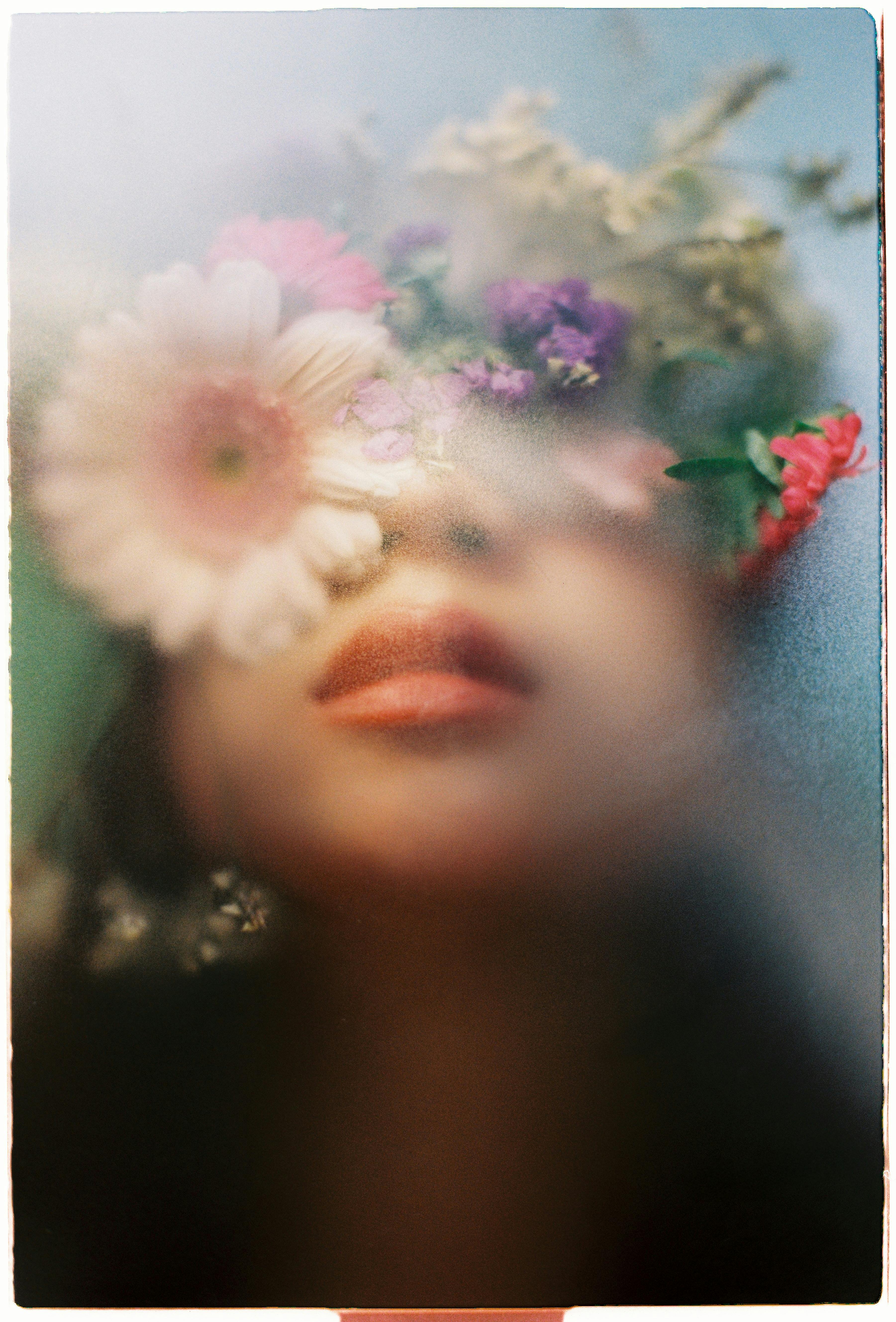 Artistic portrait with flowers and soft light, evoking a dreamy mood.