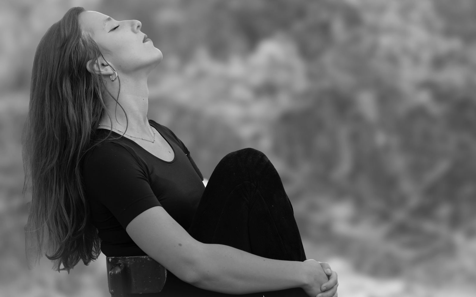 Woman breathing peacefully with eyes closed in a calm outdoor setting