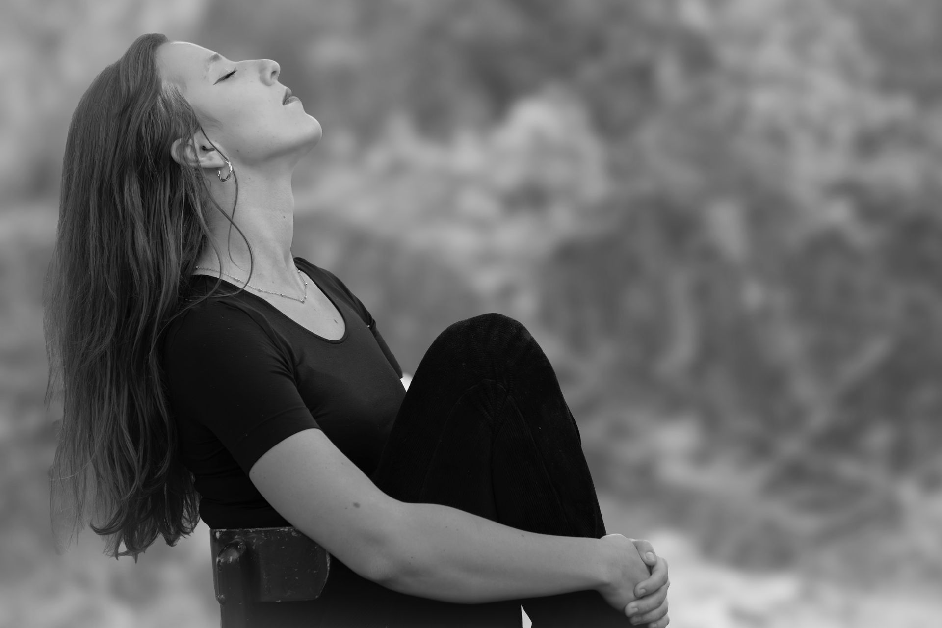 A woman meditates peacefully outdoors with closed eyes, embracing serenity