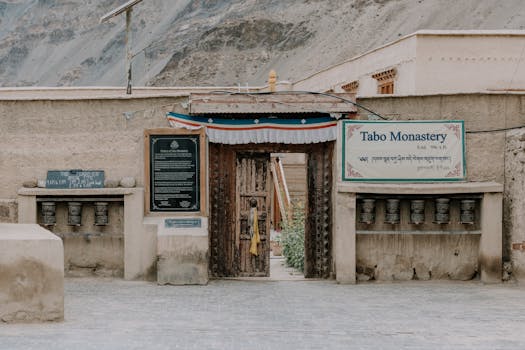 A tranquil view of the entrance to Tabo Monastery, Himachal Pradesh, surrounded by serene mountains.