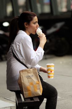 A woman enjoying McDonald's ice cream outdoors in Kuala Lumpur, Malaysia.