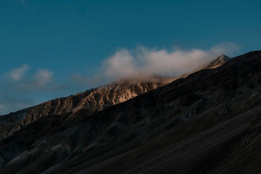 Golden light illuminates rugged peaks of the Himalayas in Marango Rangarik, Himachal Pradesh during sunset.