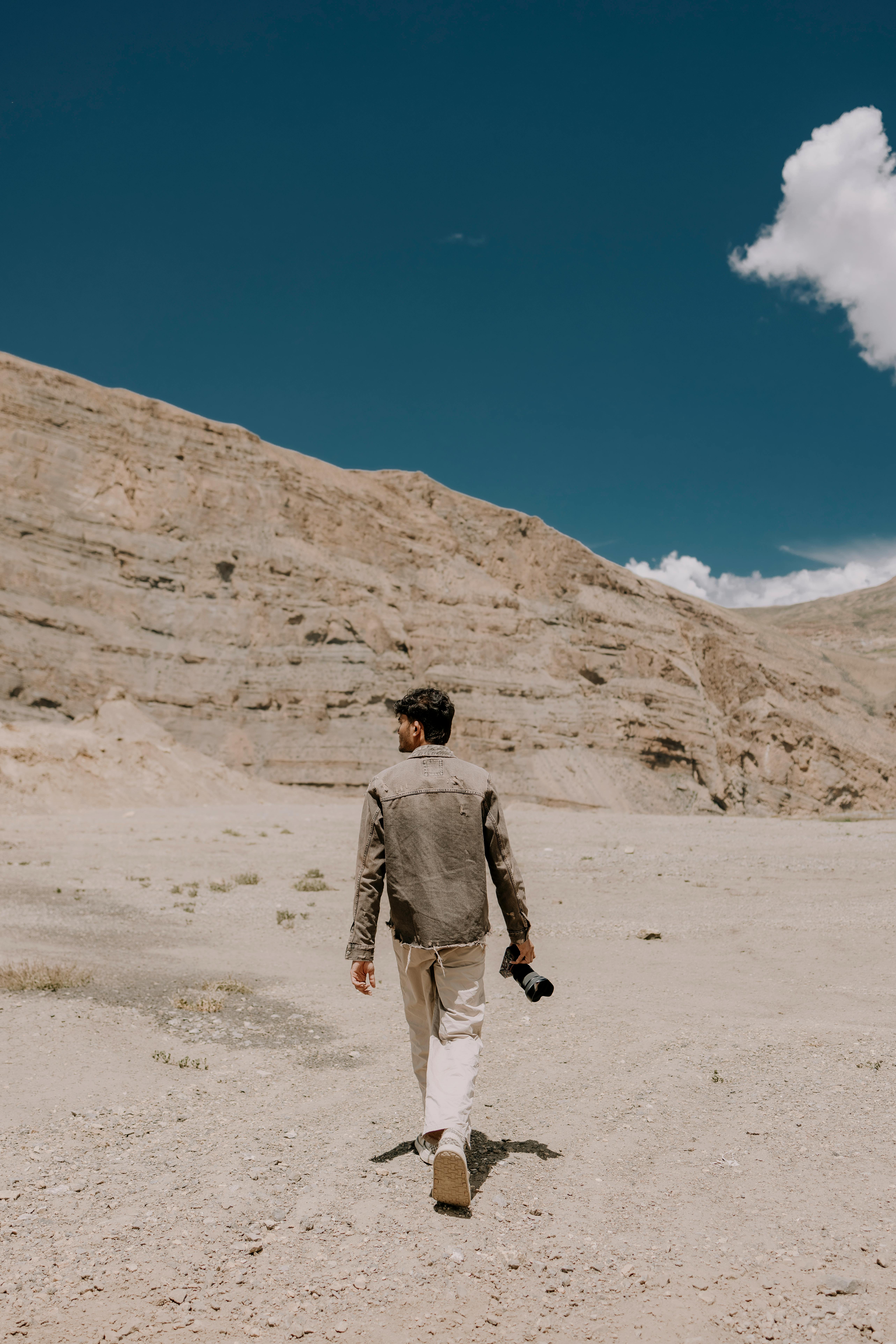 Man walking in Spiti Valley, Himachal Pradesh, India with a camera.