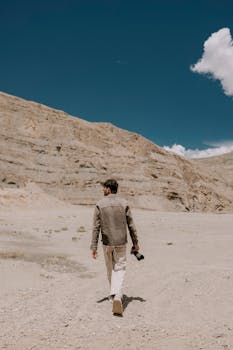 Man walking in Spiti Valley, Himachal Pradesh, India with a camera.