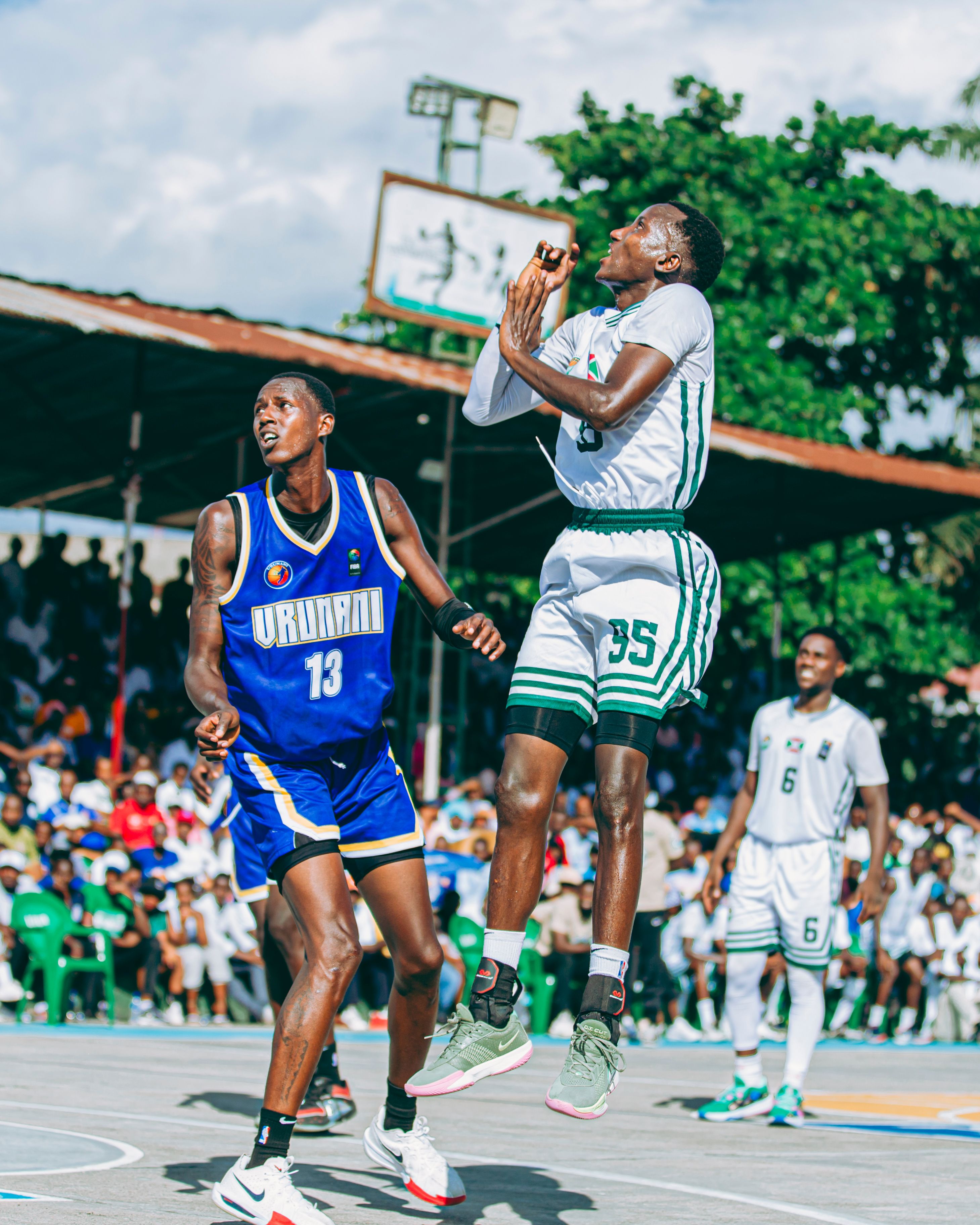 Two athletes compete in an intense outdoor basketball game.