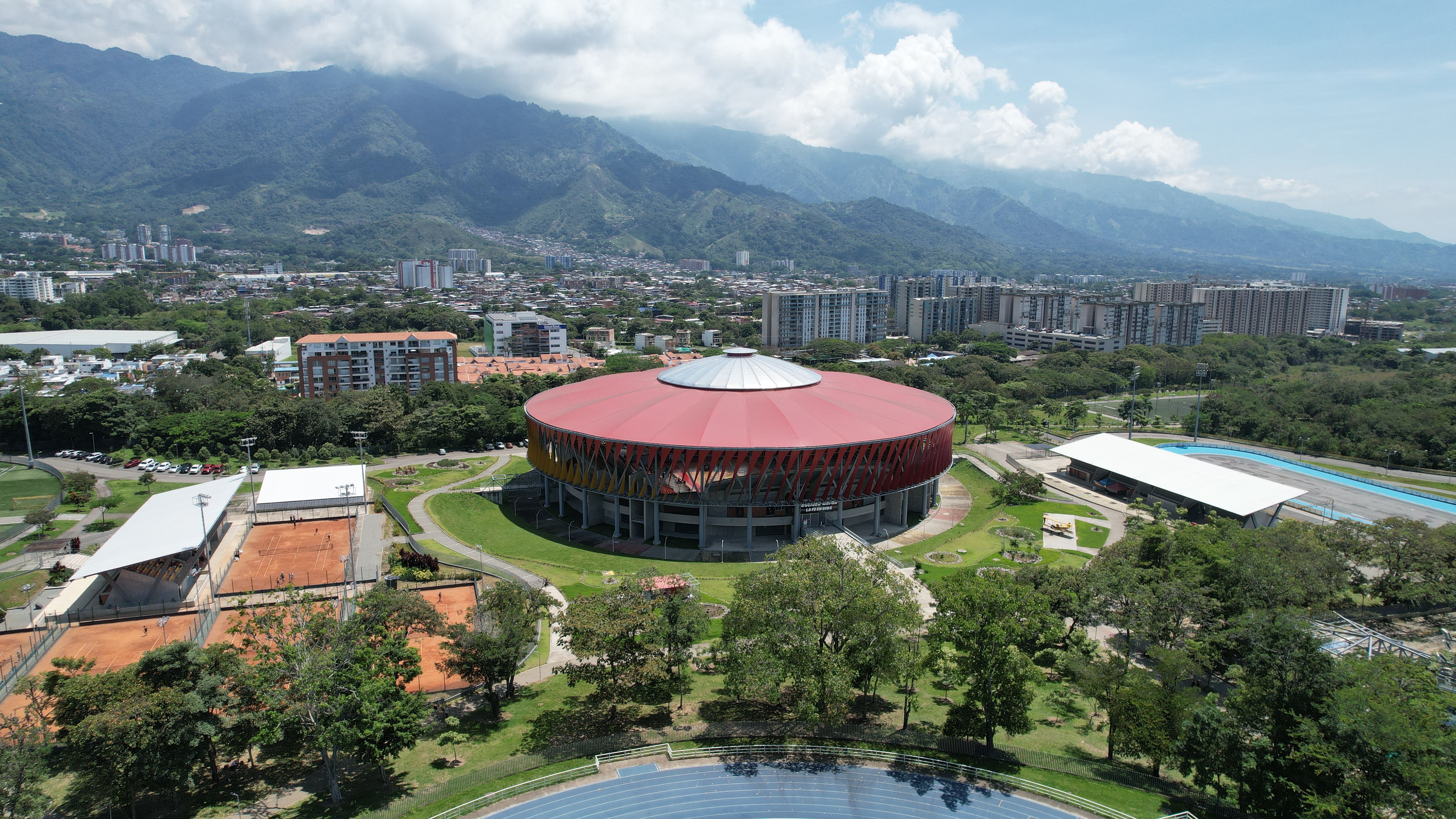 Stunning Private Helicopter Tour of Medellin and the Graffiti Area Review 2026 - Aerial shot of a modern stadium in Ibagué, Colombia, surrounded by lush greenery and cityscape.