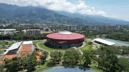 Free Aerial shot of a modern stadium in Ibagué, Colombia, surrounded by lush greenery and cityscape. Stock Photo