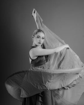 Graceful ballerina captured in dynamic pose, showcasing elegance in black and white.