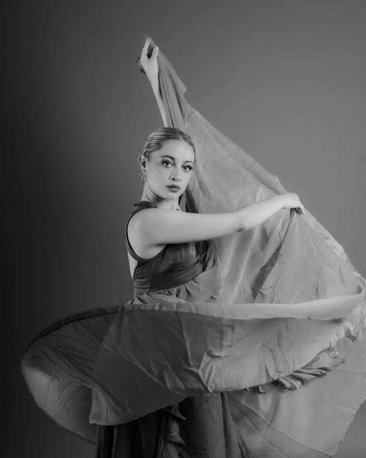 Graceful ballerina captured in dynamic pose, showcasing elegance in black and white.