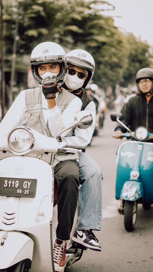Free Group of people riding scooters on a busy street in East Java, Indonesia. Stock Photo