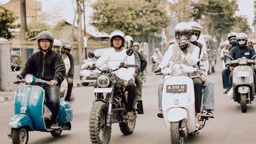 Free Group of diverse motorcyclists riding through a street in East Java, Indonesia. Stock Photo