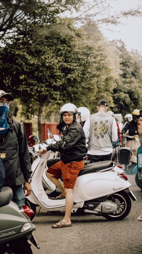 Free A cheerful motorcyclist on a Vespa, enjoying a lively day in East Java, Indonesia. Stock Photo