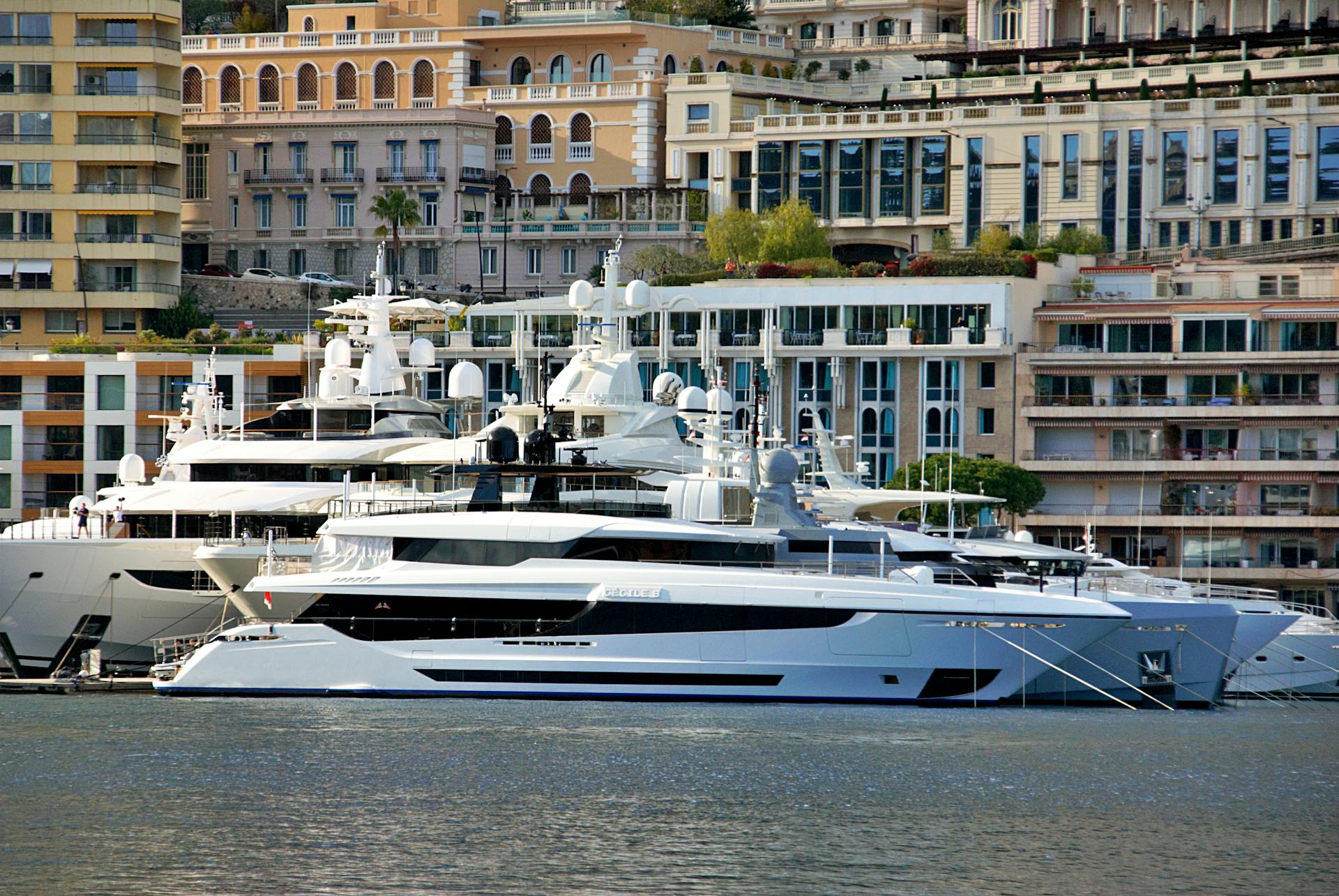 Stunning view of luxury yachts docked at Monaco harbor with elegant architecture in the background.