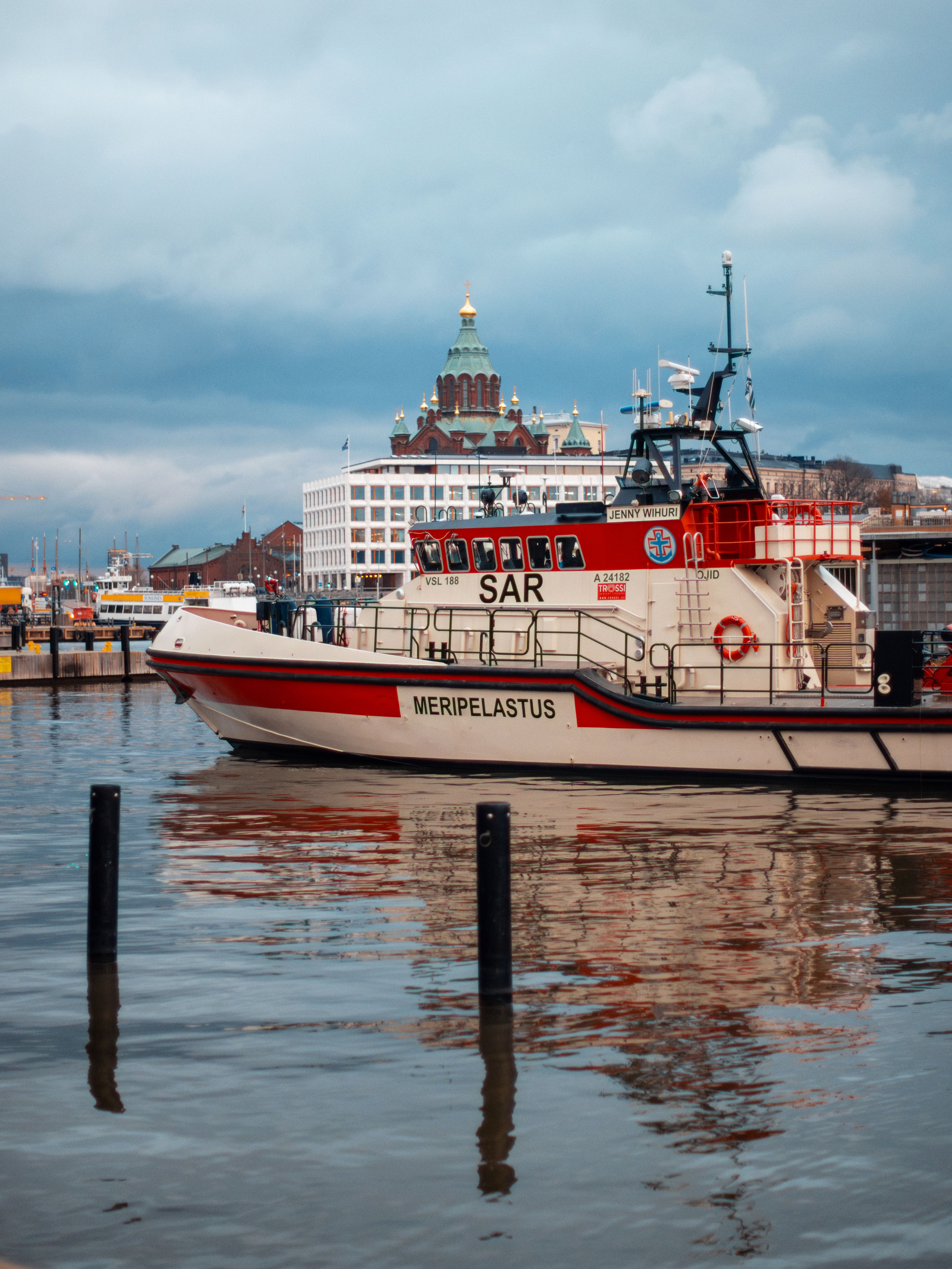 Stunning view of Helsinki harbor showcasing a rescue boat and Uspenski Cathedral in the background.